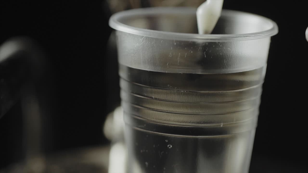 Pouring milk into a plastic cup