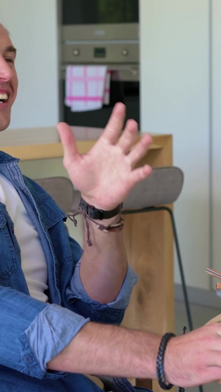 Video verticale: Uomo in denim che si tocca il naso, spiega e indica uno strofinaccio da cucina, con spazio per il testo.