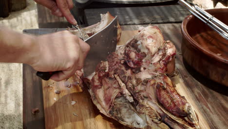 hombre corta cabeza de cerdo asado en un picnic