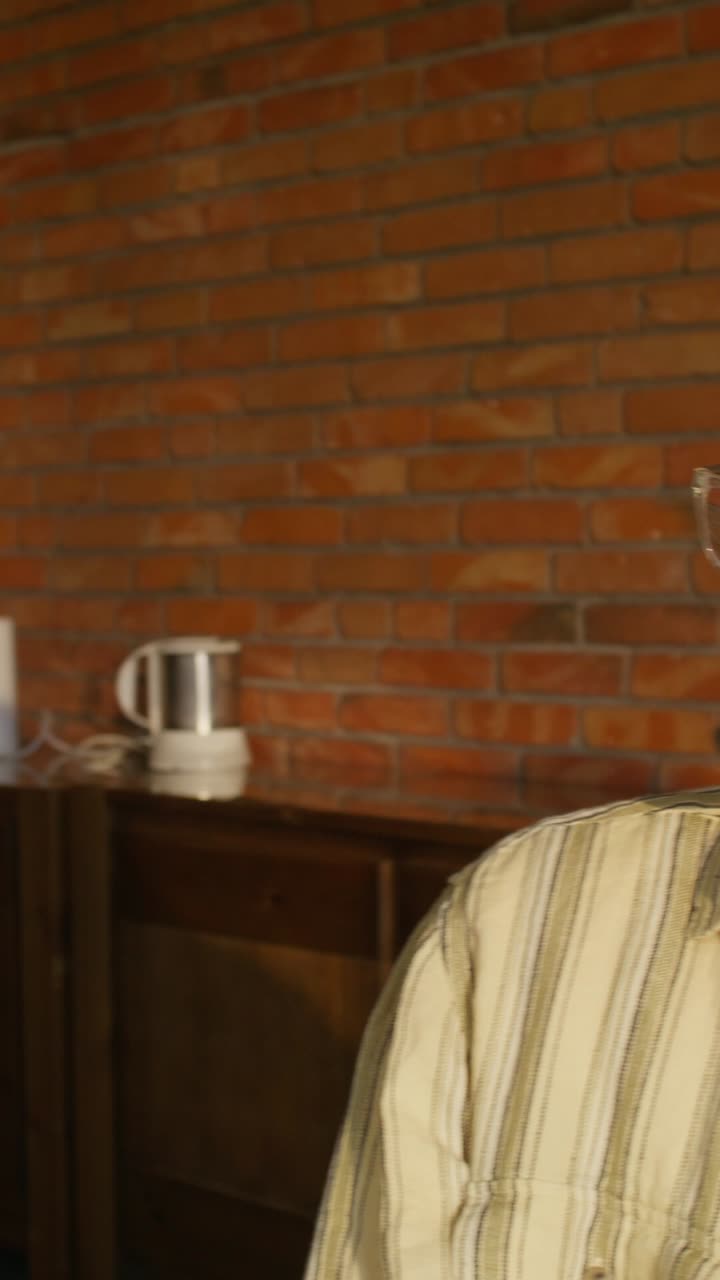 벽돌 벽과 식물이 있는 방에 있는 사람