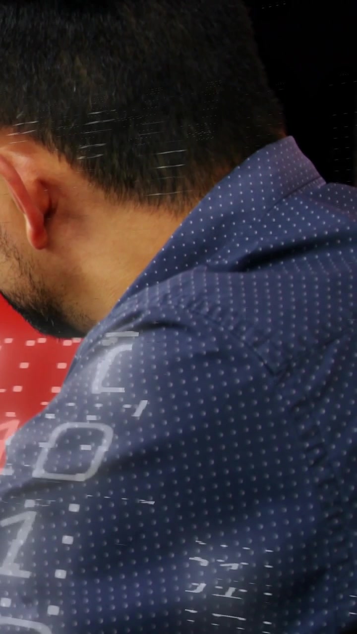 Vertical video: Camera panning, man turning while overlaying dots across shirt, showing tech data