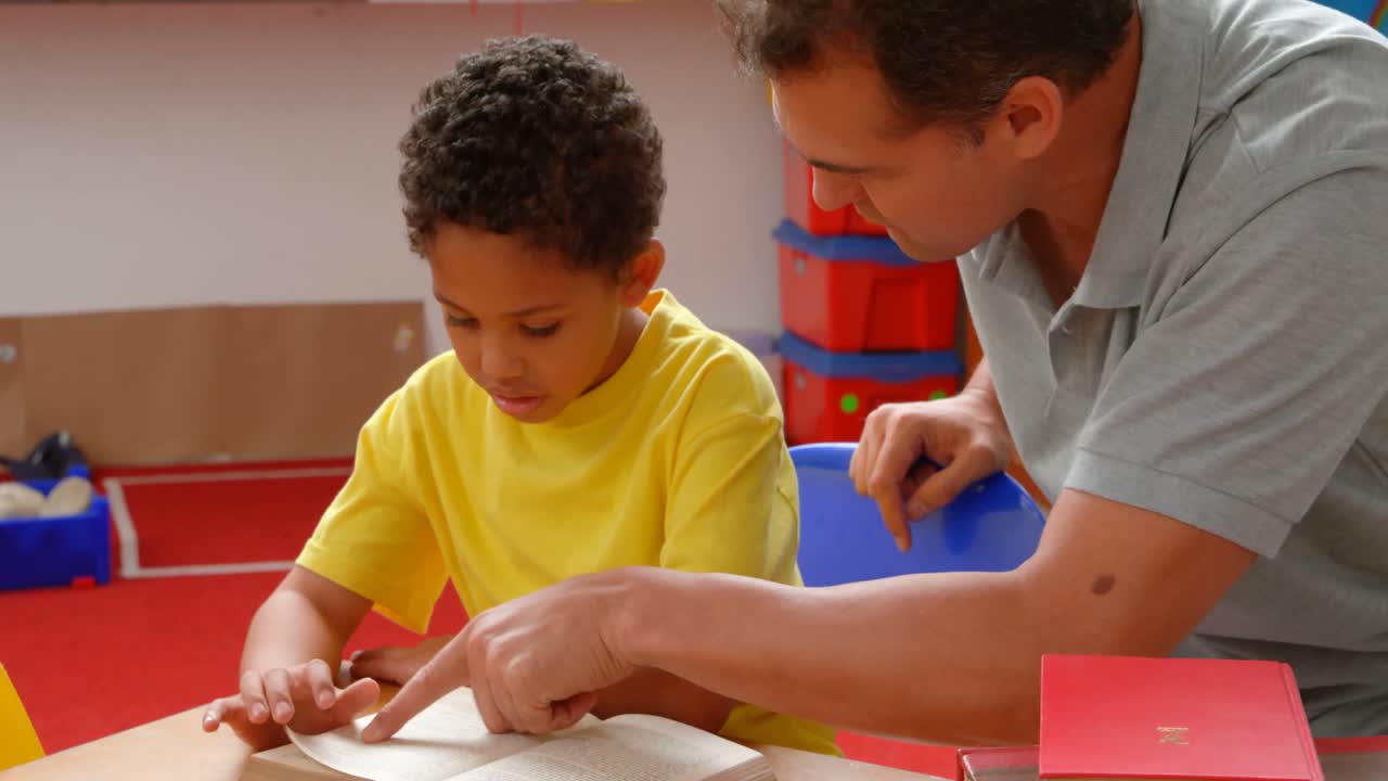vista frontal de un joven maestro caucásico que enseña a un escolar afroamericano en el aula 4k