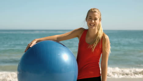 Glückliche-Frau-Mit-Gymnastikball-Am-Strand-