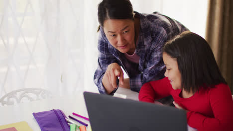 video de una madre y una hija asiáticas felices haciendo la tarea juntos