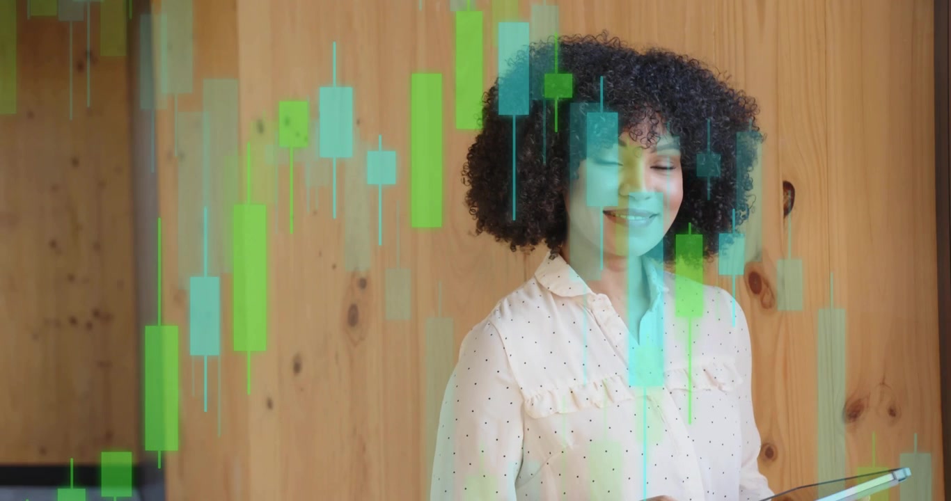 Femme d'âge moyen tapotant une tablette dans une salle de finance, étudiant des graphiques en chandeliers holographiques émergents en hausse.