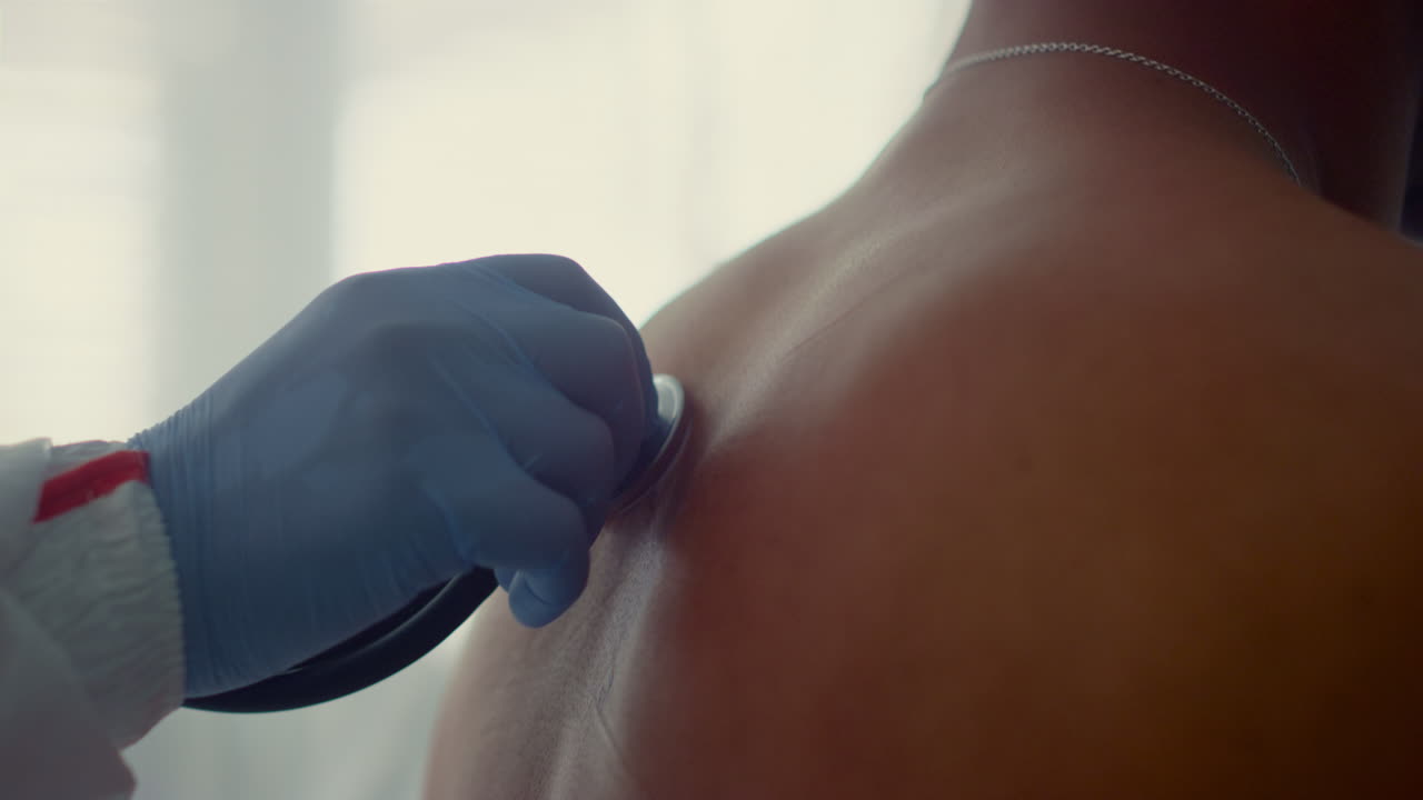 médico escuchando al paciente de vuelta en la sala de cerca. chequeo de salud unidad infecciosa