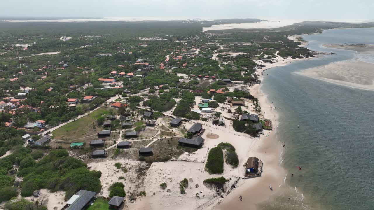 A beach town near lencois maranhenses, showing lush green areas and sandy shores, aerial view