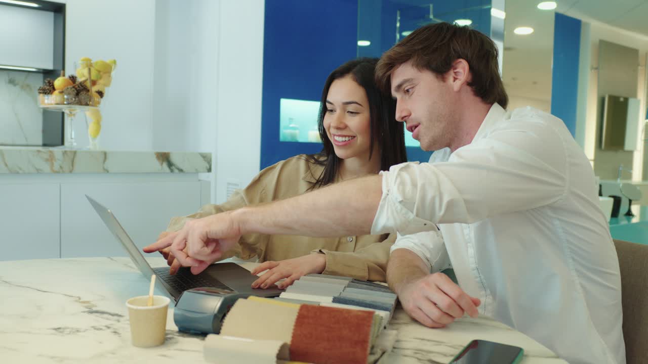 A couple looking at a laptop in a furniture store