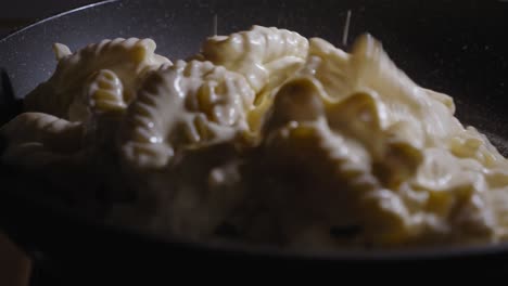 Close-up-View-Of-Hand-Adding-The-Cheese-Pie-Ingredients-To-A-Frying-Pan---Steady-Shot