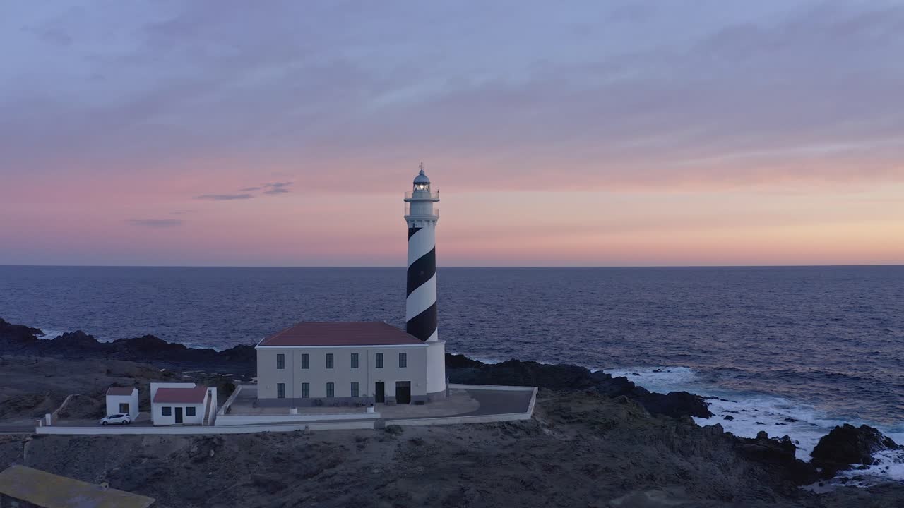 закат солнца на маяке фаварикс в меноре, испания с полетом беспилотника вокруг сооружения