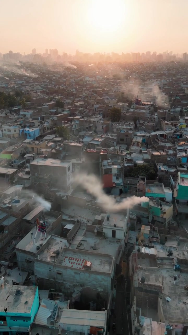 Vista aerea velata di tetti affollati di una città indiana all'ora d'oro