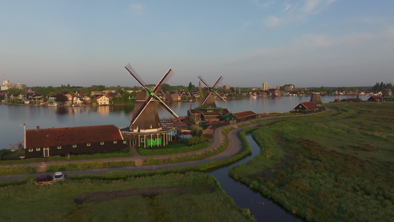 Aerial view of traditional windmills glowing beautifully at sunrise at the iconic Zaanse Schans in North Holland