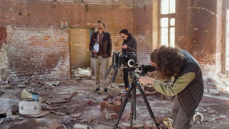 production worker setting up a camera in a ruined building