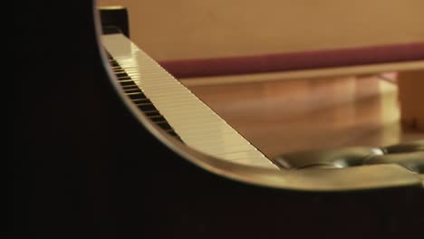 Close-up-shot-of-the-keys-of-a-baby-grand-piano-inside-a-church-sanctuary