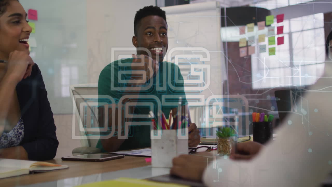 Animation of big data text over diverse man sharing ideas with coworkers in office