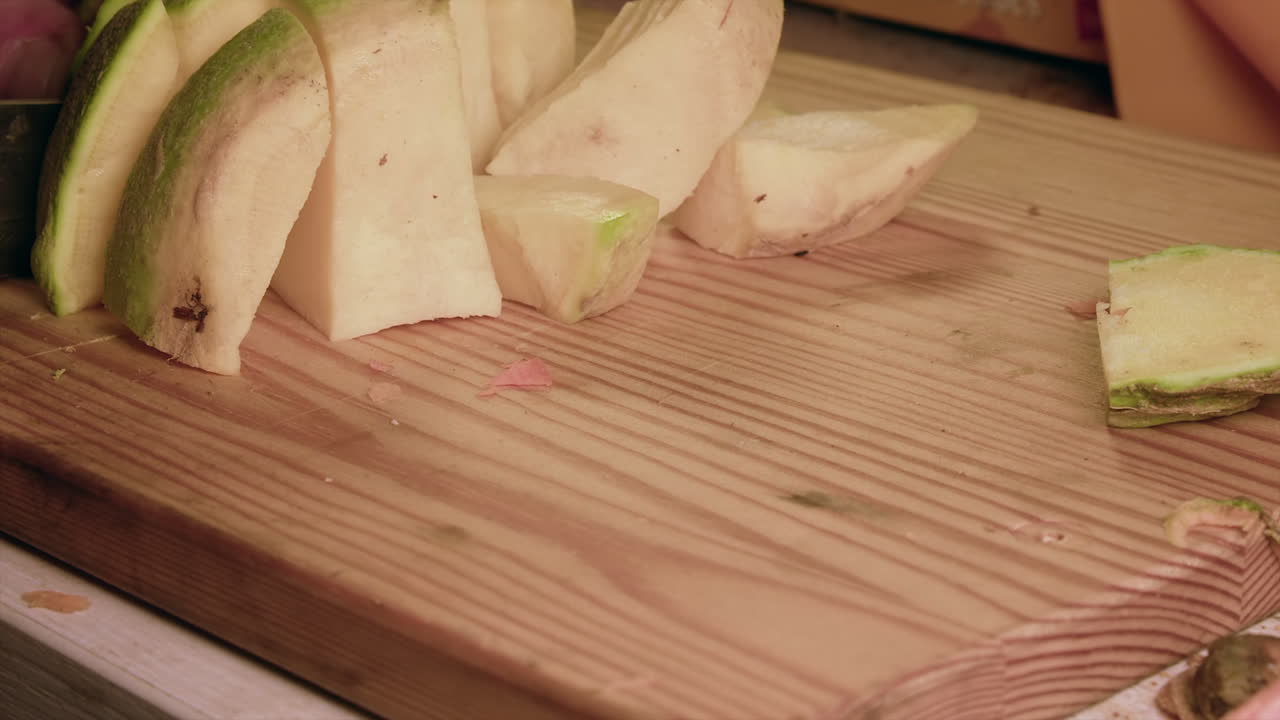 rutabaga sueca cruda firme cortada en cubos en una tabla de cortar de madera