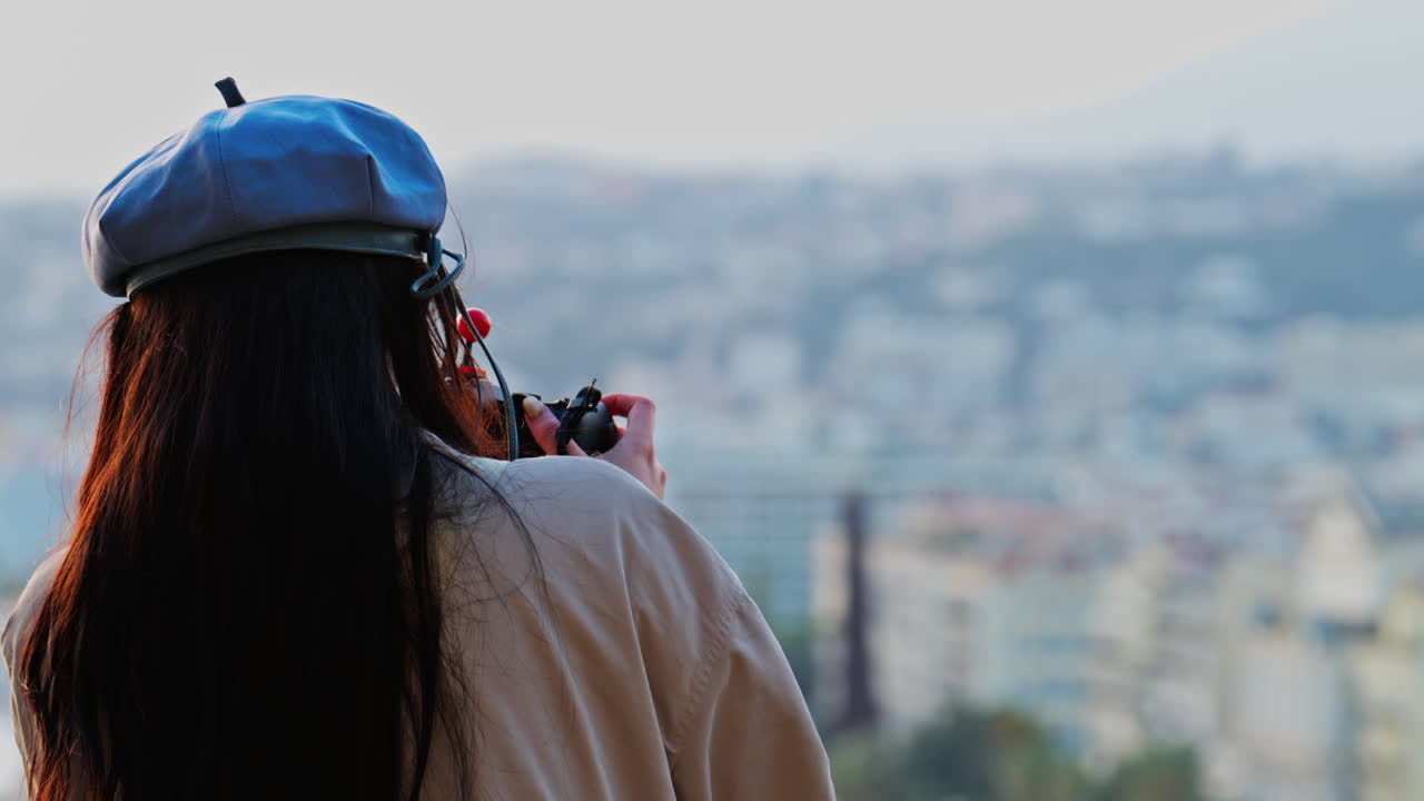 Woman in a blue beret taking pictures of the coast of France on a professional camera