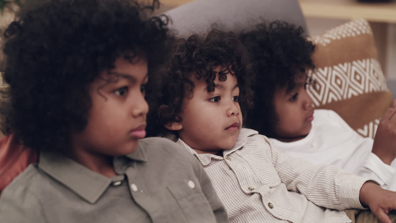 tres niños sentados en un sofá