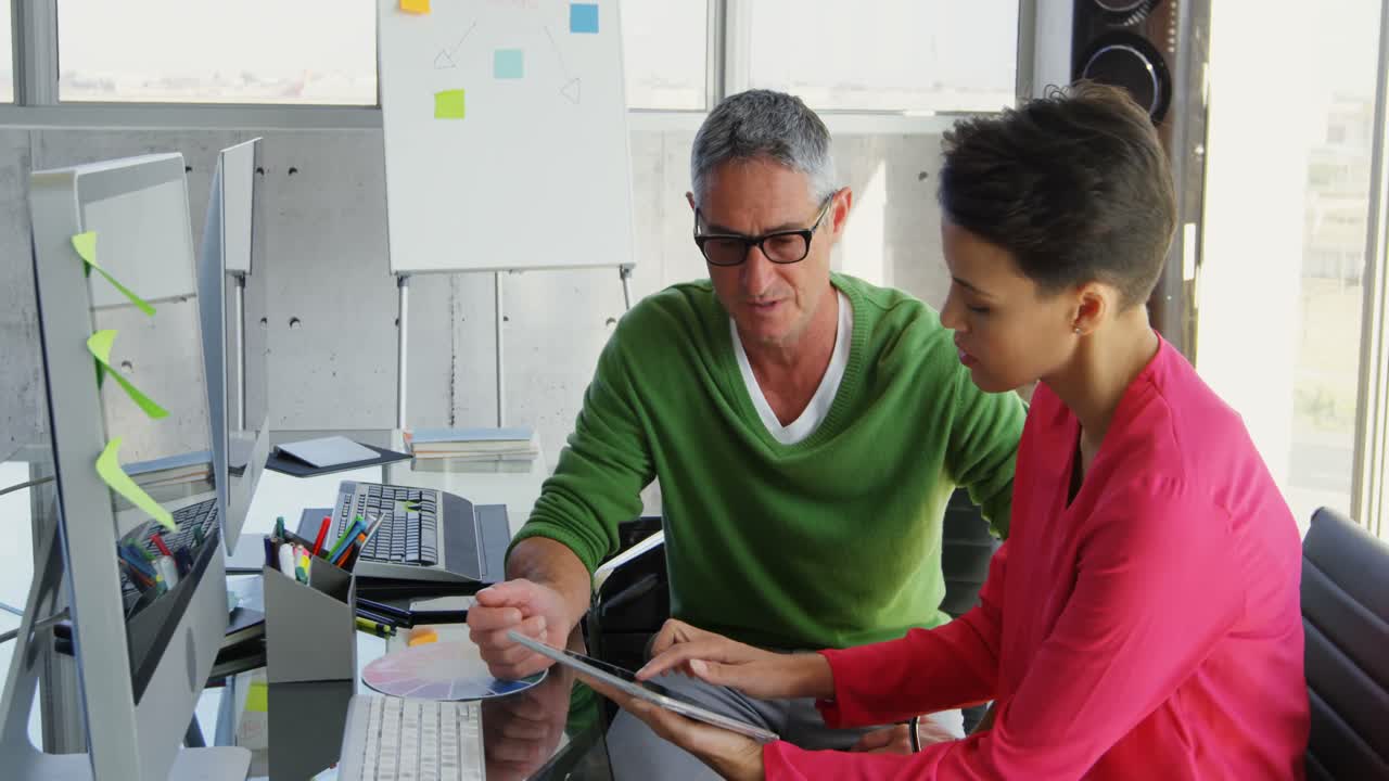 gente de negocios caucásica discutiendo sobre una tableta digital en el escritorio en la oficina 4k