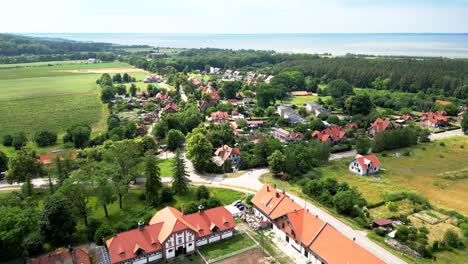 drone flight over the buildings of the old manor in kadyny, view of buildings, trees, rural structures, and a bay