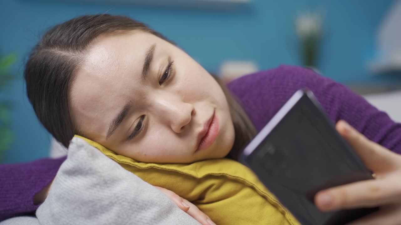 전화로 문자 메시지를 보내는 아시아 여성은 그녀가 본 메시지로 인해 우울해졌습니다.