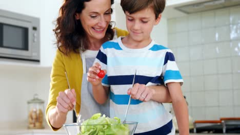 madre e hijo mezclando la ensalada en la cocina