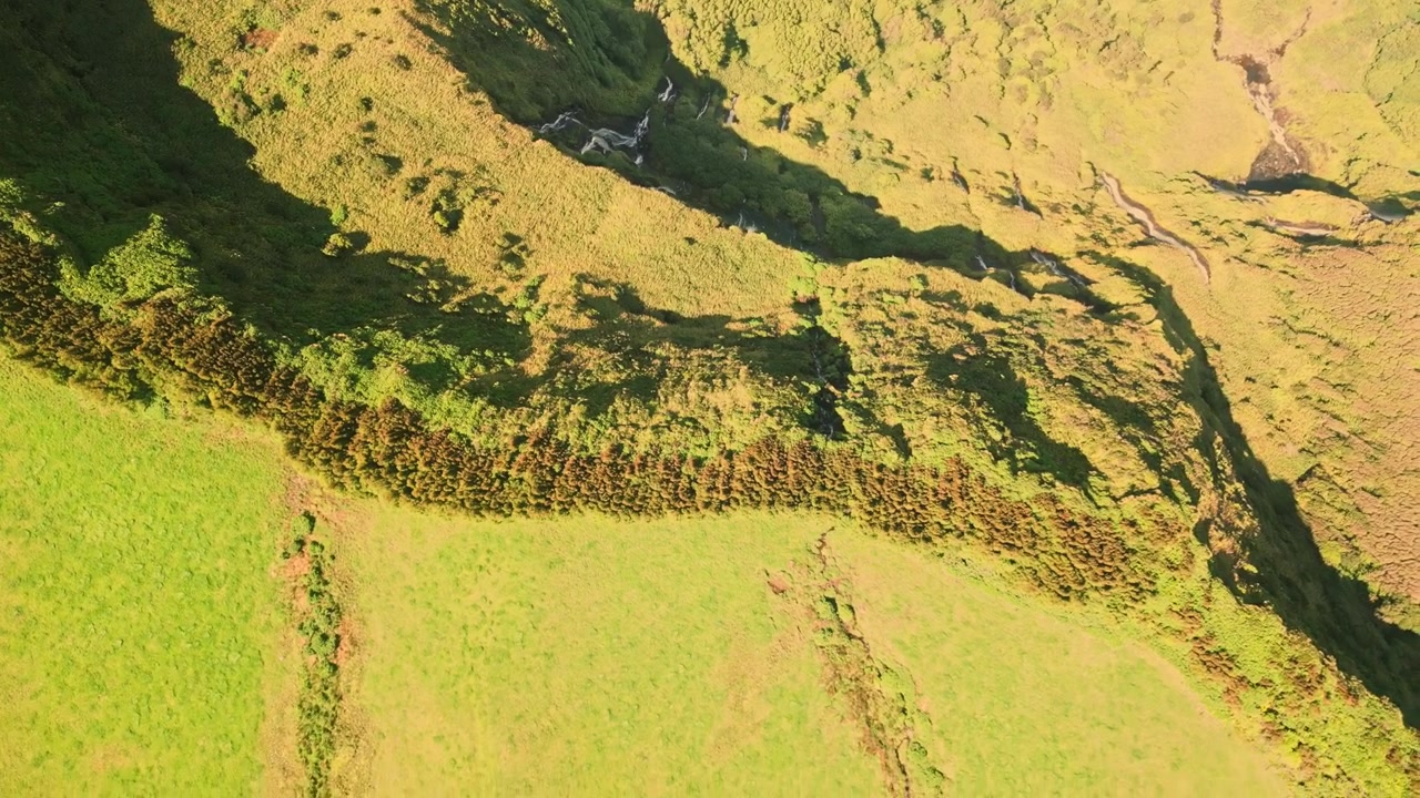 Vista aerea che sorvola rigogliose colline e creste verdi con luce solare e ombre, Flores.