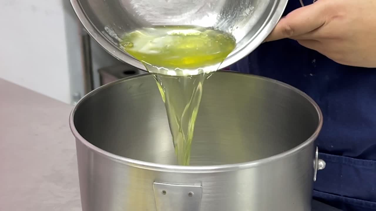 파티시에가 달걀 흰자위를 붓고 캐스터 설탕을 혼합 그릇에 넣어 혼합, 상업용 주방 설정, 홈메이드 맛있는 페이스트리, 슬로우 모션