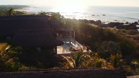 lento movimiento de drones sobre palapa villa de alquiler de lujo frente al mar en el océano pacífico oaxaca mexico 4k antena