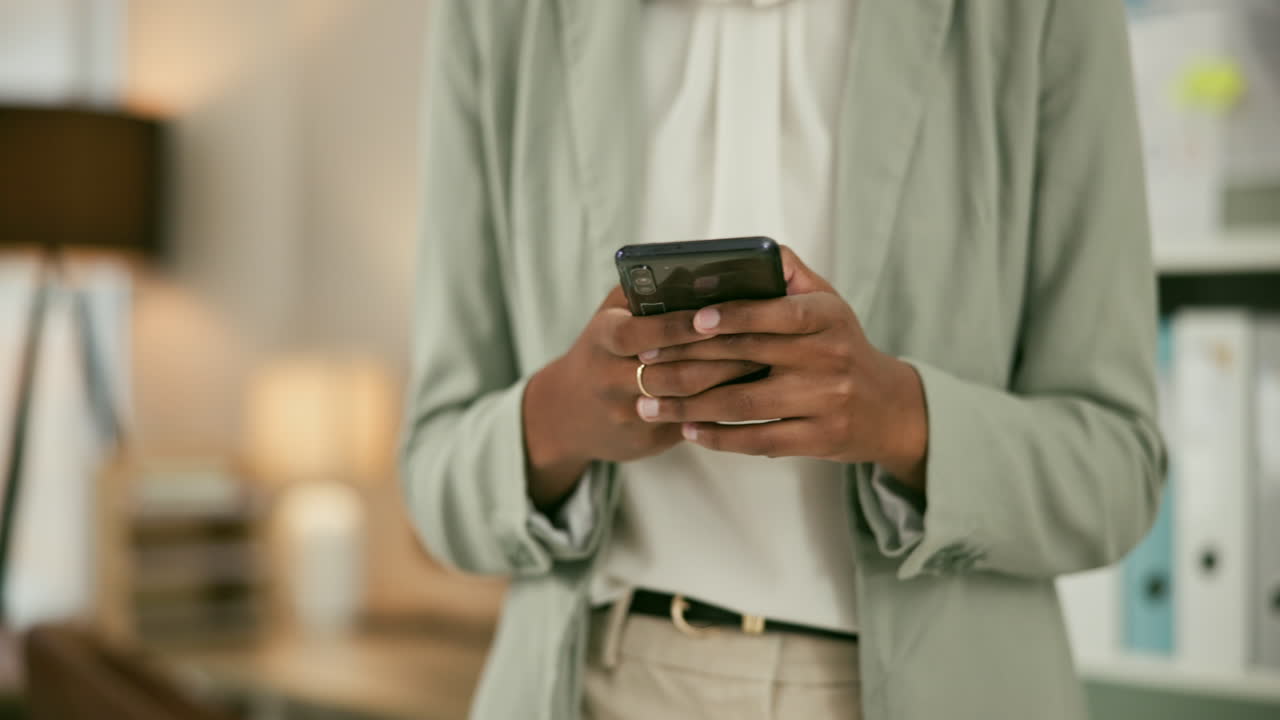 Kvinde skriver beskeder på smartphone på kontor