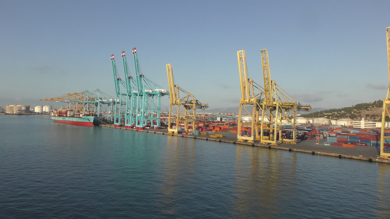 There are many containers and cranes in the port of Barcelona