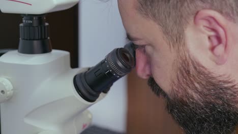 Nahaufnahme-Eines-Mannes,-Der-In-Ein-Mikroskop-Schaut