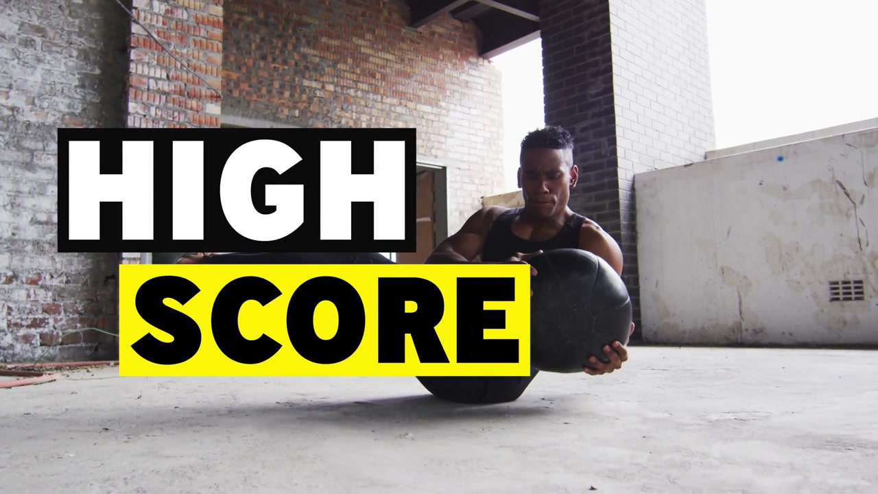 Man starting V-hold, twisting core with medball for fitness as HIGH SCORE overlays sliding over him