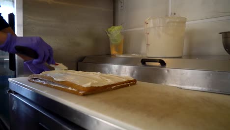 a chef spreads icing on a cake