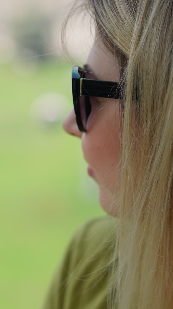 Thoughtful blonde woman tourist with sunglasses drives cabin of modern cable way enjoying landscape at mountain resort closeup slow motion