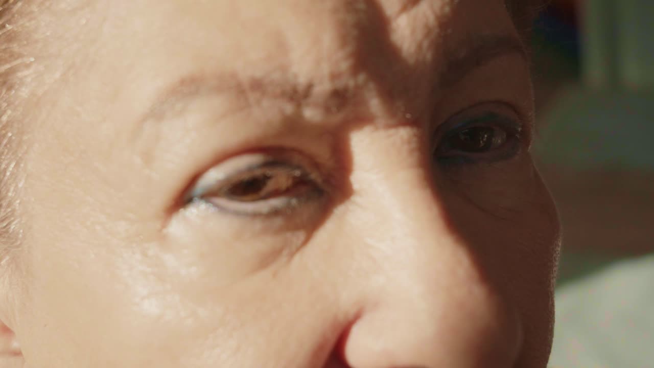 Oudere vrouw kijkt in de camera en heeft problemen met het gezichtsvermogen als gevolg van gesprongen bloedvaten in het oog