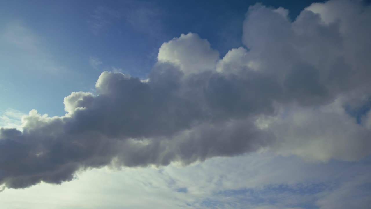 Smoke from industrial plant against a blue sky with clouds