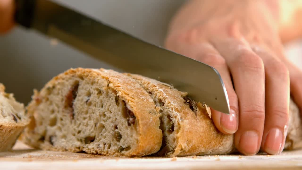 Woman cutting loaf of bread 4k