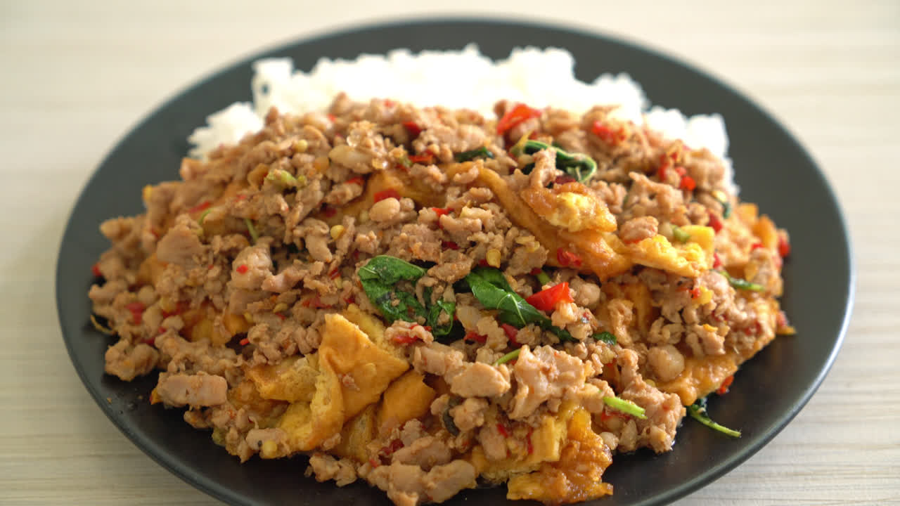 cerdo picado salteado con albahaca y huevo cubierto con arroz - estilo de comida asiática