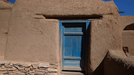 an adobe building with a blue door