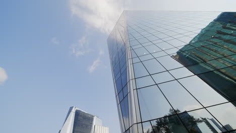 low wide angle of glass business building of blue mirrors on the downtown financial area of a big city in a pretty day of blue sky