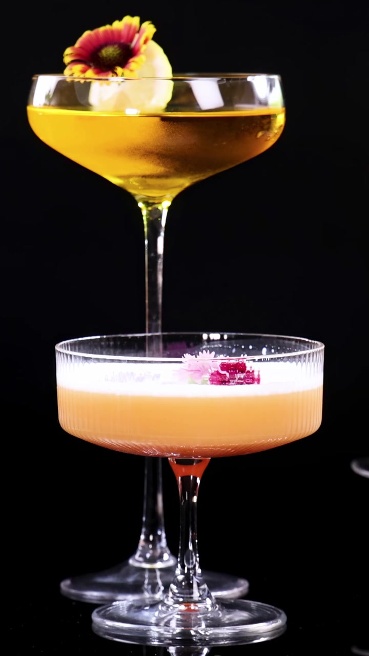 Una varietà di cocktail vivaci vengono fatti tintinnare in un brindisi celebrativo, su uno sfondo scuro.