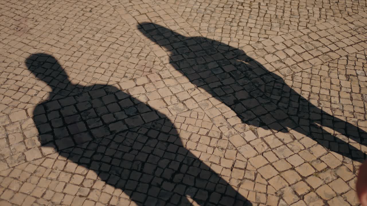 Couple's Shadows on Cobblestone Street