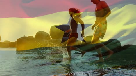 animation of flag of ghana over diverse group of friends at beach