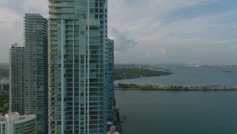 slide and pan shot of modern high rise apartment buildings. paraiso bay residences on waterfront. miami, usa