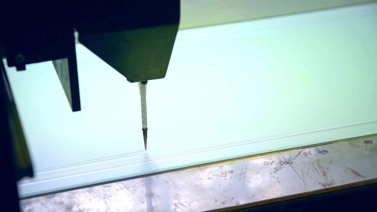 Modern equipment at the factory producing doors. Machine-tool applying picture on the glass. Close up.