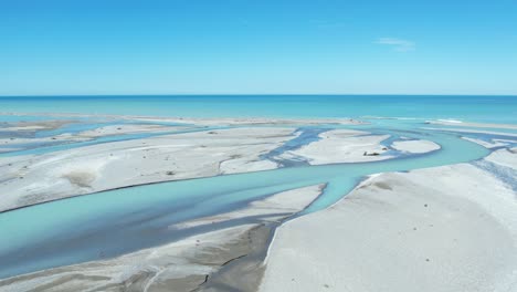 Aerial-traverse-and-descent-across-beautiful-turquoise-colored-Rakaia-River-as-it-exits-into-ocean