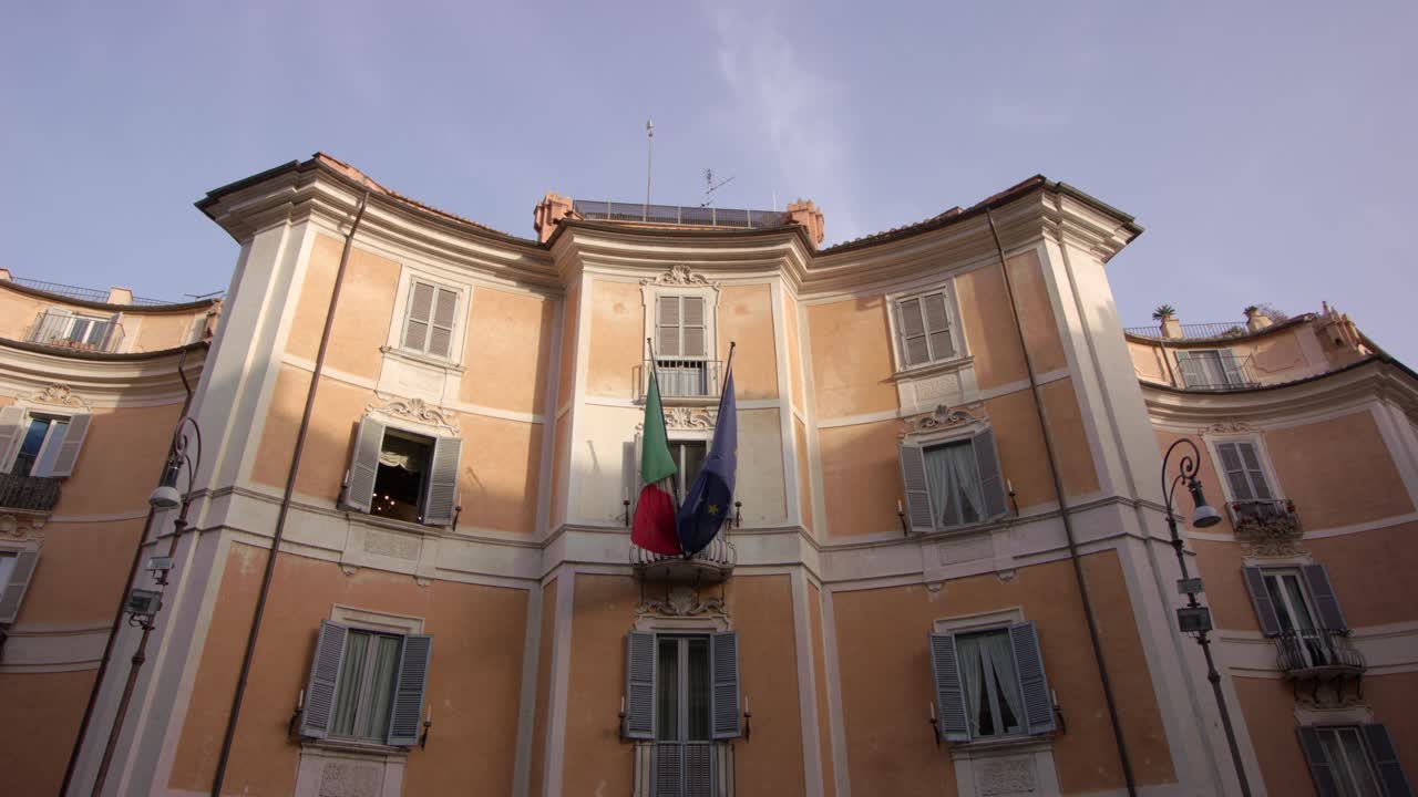 Historic Italian government building displaying national and EU flags under bright clear sky showcasing classic architecture and European heritage in a peaceful city setting Outdoors