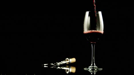 Red-wine-poured-in-wine-glass-against-black-background-4k