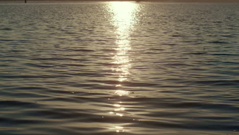 Agua-Que-Refleja-La-Luz-Dorada-Del-Sol-Al-Atardecer.-Ondas-Tranquilas-Del-Lago-Ondeando.